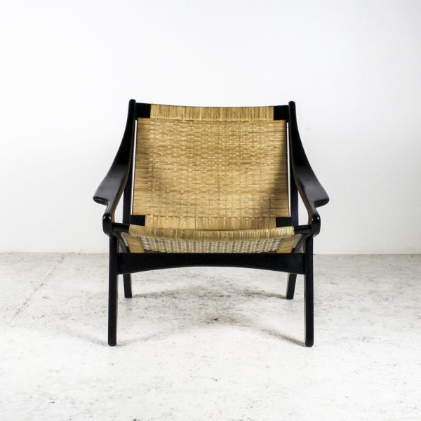 Fauteuil rétro des années 50, assise en rotin, piétement en bois laqué noir.