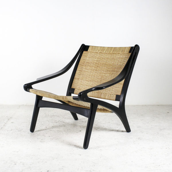 Fauteuil rétro des années 50, assise en rotin, piétement en bois laqué noir.