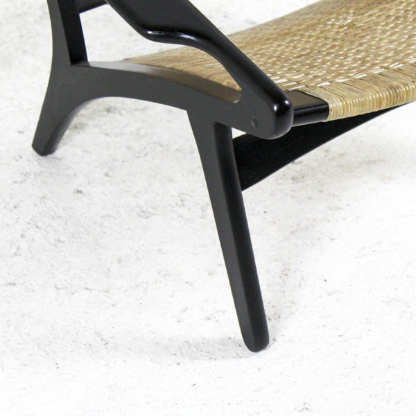 Fauteuil rétro des années 50, assise en rotin, piétement en bois laqué noir.