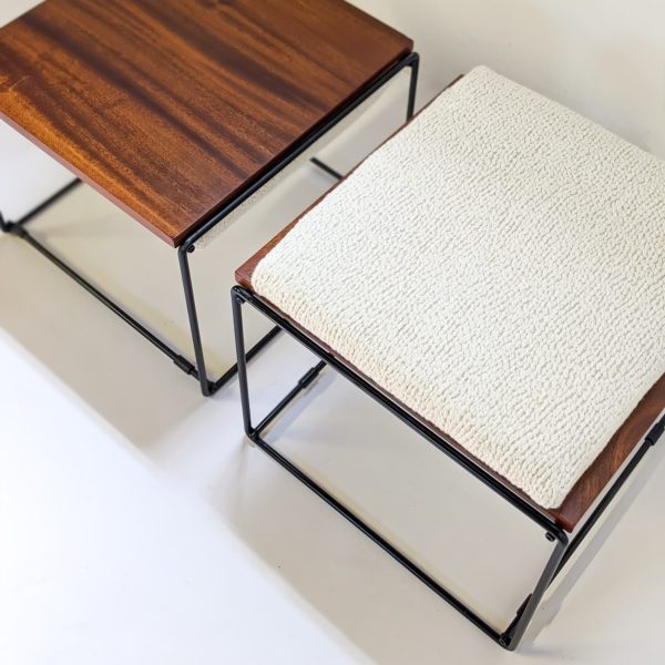 Paire de tables basses/tabourets vintage à plateaux réversibles en acajou, coussin en mousse refaite à neuf, recouverte d'un tissu de la Maison Pierre Frey, piétement en métal laqué noir. Travail français des années 50.